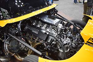 Race engine from Westside Machine with black hoses installed in yellow race car