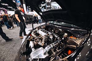 Man in aisle looking at engine in race car