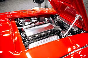 Silver engine with Corvette valve covers installed in red Corvette