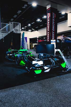 Racing simulator with black and green car in background