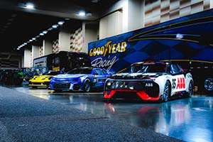 Race vehicles lined up in front of Goodyear Racing trailer