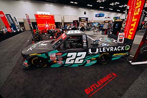 Black and green race truck with 22 on side in Butlerbuilt booth