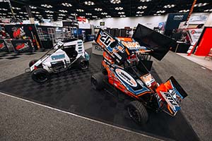 White midget race car on left and orange and black 20RT micro sprint car with wing on right