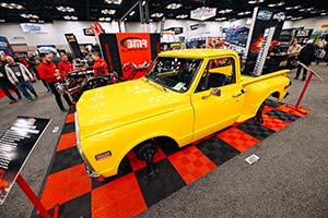 Yellow truck without wheels on red and black flooring