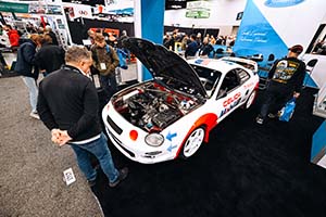 Two men looking at white Toyota Celica