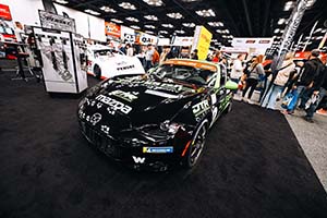 Black Mazda MX-5 with green side mirrors