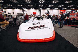 White dirt late model with red bumper and Penske Racing Shocks logo on hood