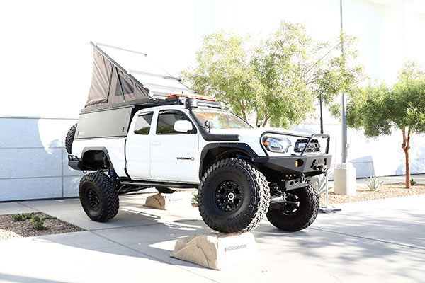 Toyota Tacoma with front wheel on large rock